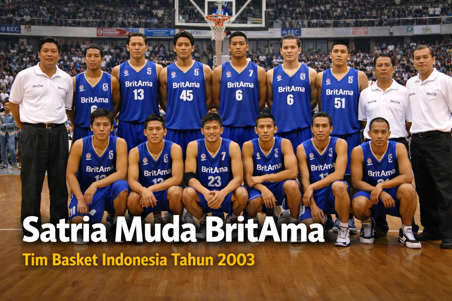 Skuad Satria Muda BritAma tahun 2003 berpose bersama di lapangan basket indoor, mengenakan jersey biru dengan latar penonton di tribun