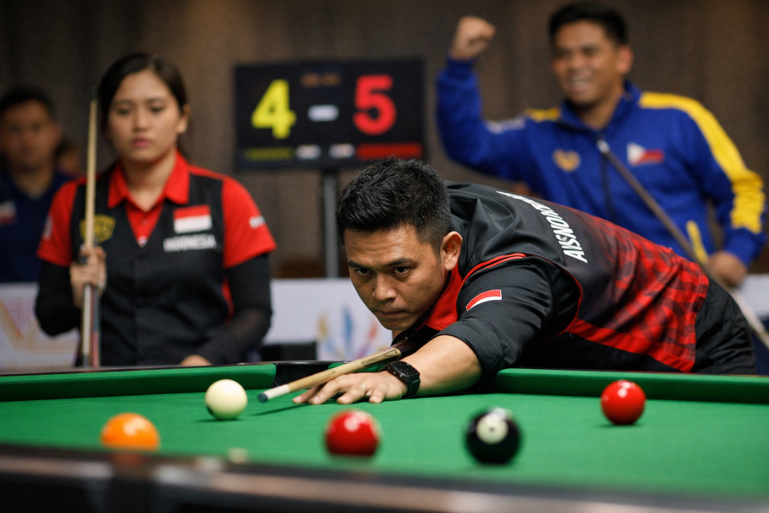 Pebiliar Indonesia sedang melakukan pukulan di meja biliar pada pertandingan SEA Games 2025, dengan ekspresi fokus dan latar suasana pertandingan yang tegang